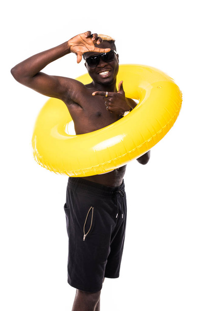 Young african man with sunglasses and summer clothes with rubber ring on white background - Photo, Image