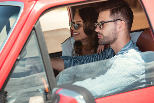 handsome man driving car with his happy girlfriend - Zdjęcie, obraz