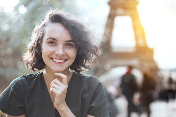 portrait of a happy smiling girl against the background of the Eiffel Towerin Paris. France - Fotografie, Obrázek