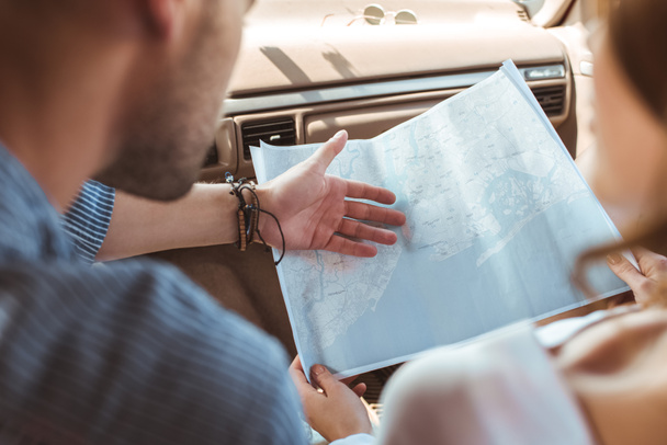 cropped view of travelers looking at map inside the car  - Fotografie, Obrázek
