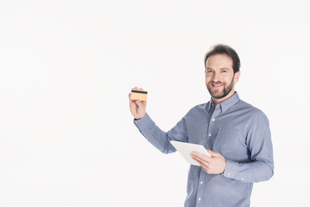 портрет улыбающегося мужчины с цифровым планшетом, показывающим кредитную карту, изолированную на белом
 - Фото, изображение