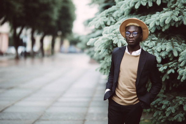 Νέος όμορφος Αφρικανικός Αμερικανός επιχειρηματίας με καπέλο περπατώντας στο δρόμο - Φωτογραφία, εικόνα