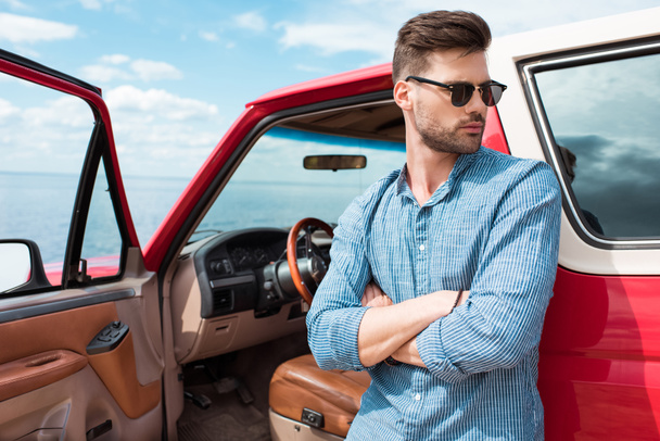 handsome stylish male traveler standing at red car near the sea - Valokuva, kuva