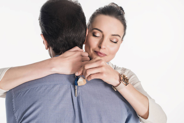 partial view of woman with key from new house hugging husband isolated on white - Photo, image