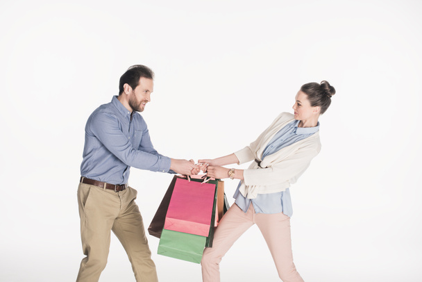 vista lateral do casal encostando sacos de compras isolados no branco
 - Foto, Imagem