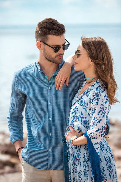 beautiful young couple in sunglasses hugging together - Photo, Image