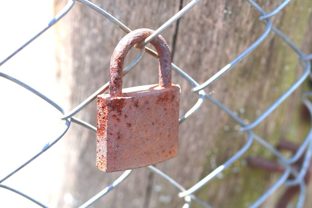 velho cadeado enferrujado em uma cerca de ferro close-up
 - Foto, Imagem