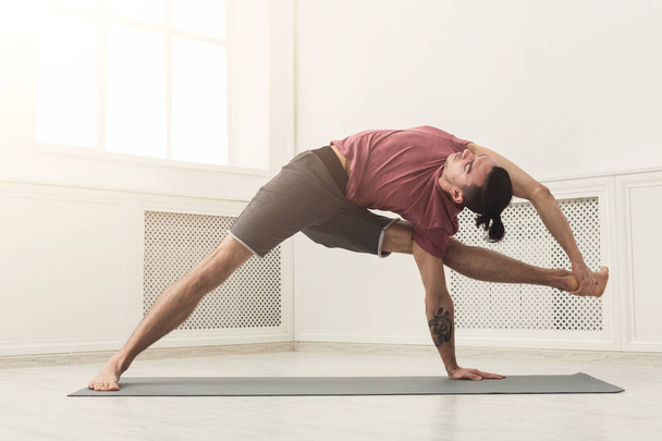 Mann streckt Rücken und Beine im Fitnessstudio - Foto, Bild