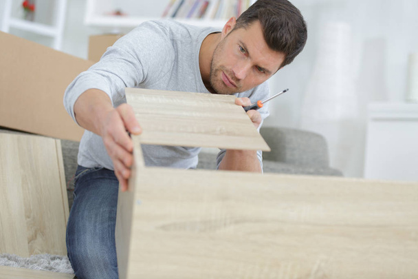 man assembling shelf at home - Foto, Bild