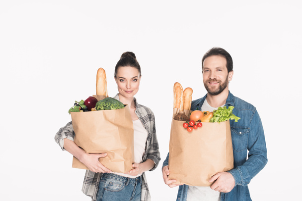 portrait of wife and husband holding paper packages with food isolated on white - Fotografie, Obrázek