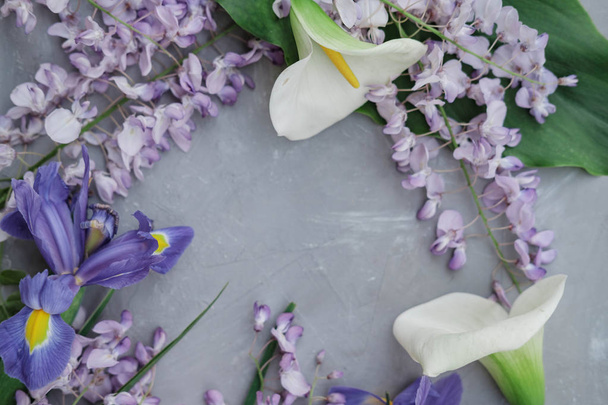 Composição de colocação plana com wisteria, íris, calos brancos no fundo branco. vista superior
 - Foto, Imagem