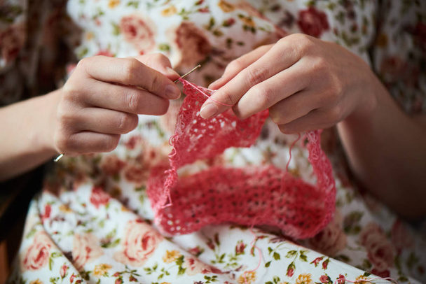 close up view of female hands knitting with pink wool, top view - Foto, Imagen