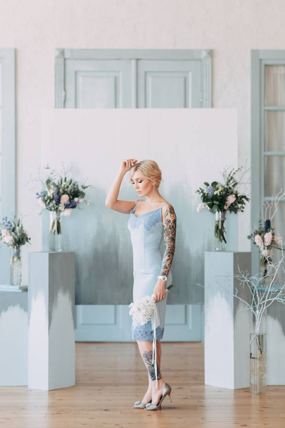 Beautiful bride in front of wedding arch with flowers and decor. Bouquet in the hands and details. The girl is happy, smiling and dancing. Dream wedding dress in modern style - Fotó, kép