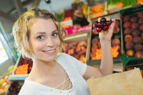 beautiful woman choosing ripe organic cherries - Φωτογραφία, εικόνα
