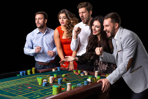 Група молодих людей за столом рулетки в казино
 - Фото, зображення