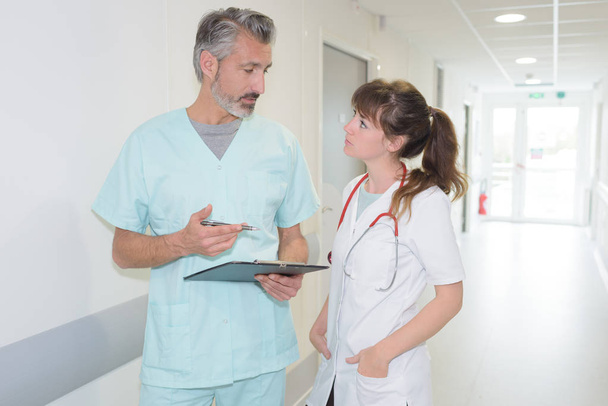 doctor and nurse discussing over report in hospital - Fotoğraf, Görsel