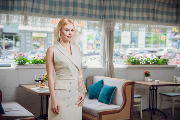 Mulher de negócios loira bonita posando em um restaurante. o proprietário do restaurante
 - Foto, Imagem