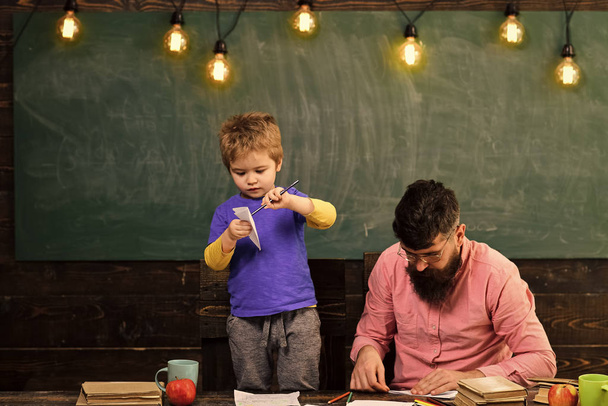Happy kid having fun. Family leisure activity. Father and cute son making paper planes. Developing kids creativity - Φωτογραφία, εικόνα