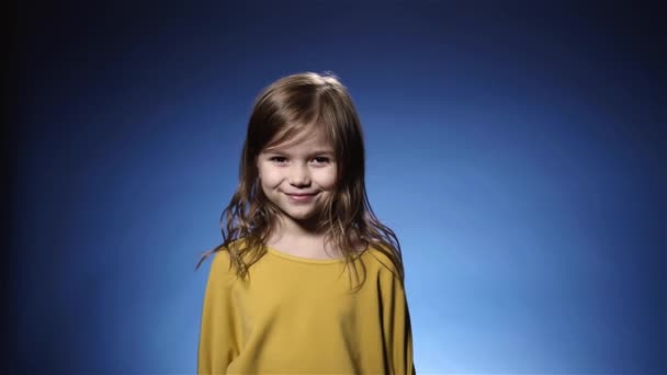 Cute little girl laughing confetti falling, cracker, blue background slow motion - Video, Çekim