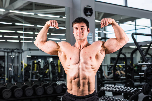 Kulturista muž s perfektní biceps, triceps a hrudníku v tělocvičně - Fotografie, Obrázek