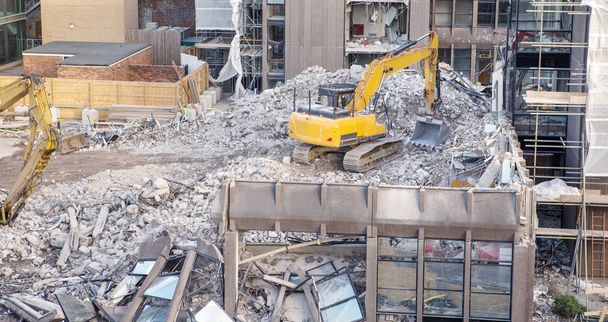 rakennustyömaalla raskaiden koneiden kaataa rakennuksen tehdä tilaa jotain uutta
 - Valokuva, kuva