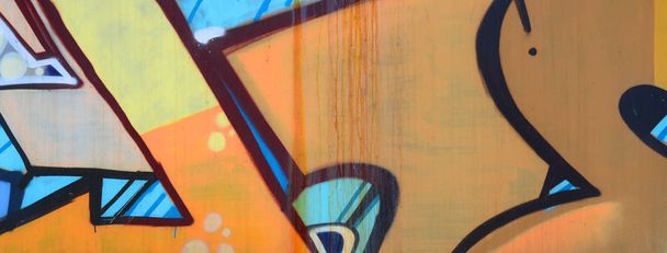 Street art. Abstract achtergrondafbeelding van een fragment van een schilderij van de gekleurde graffiti in beige en oranje tinten. - Foto, afbeelding