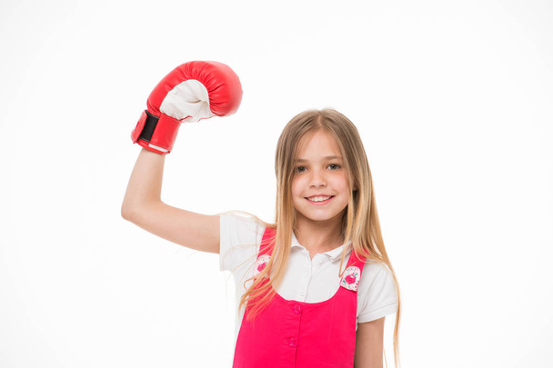 Girl on smiling face posing with boxing glove, isolated on white background. Kid girl with long hair knows how to defend herself. Girls power concept. Girl likes boxing and sporty lifestyle - Fotó, kép