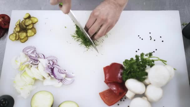 Cook chopping herbs in a restaurant, top view - Záběry, video