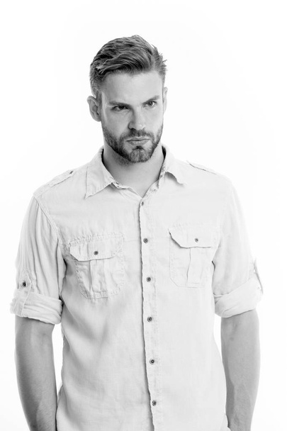 Man on calm face posing confidently with hands in pockets, white background. Man looks attractive in casual linen shirt. Guy with bristle wears casual or formal shirt. Fashion concept - Φωτογραφία, εικόνα