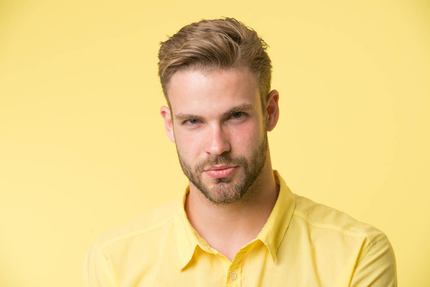 Man with bristle on confident face, yellow background. Skin care concept. Man with beard or unshaven guy looks handsome and well groomed. Guy bearded and attractive cares about his appearance - Foto, Bild