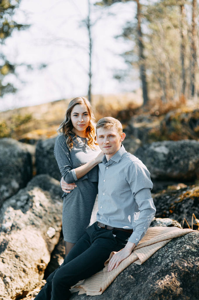 Pre-wedding photo shoot in the forest in nature, in the form of walking and traveling. Beauty of the North and Russia. Loving people and beautiful scenery. They laugh, sit and smile. Beautiful couple - Fotó, kép