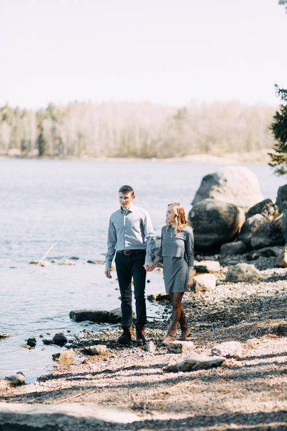Pre-wedding photo shoot in the forest in nature, in the form of walking and traveling. Beauty of the North and Russia. Loving people and beautiful scenery. They laugh, sit and smile. Beautiful couple - Фото, изображение
