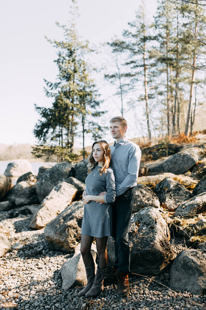 Pre-wedding photo shoot in the forest in nature, in the form of walking and traveling. Beauty of the North and Russia. Loving people and beautiful scenery. They laugh, sit and smile. Beautiful couple - Photo, image