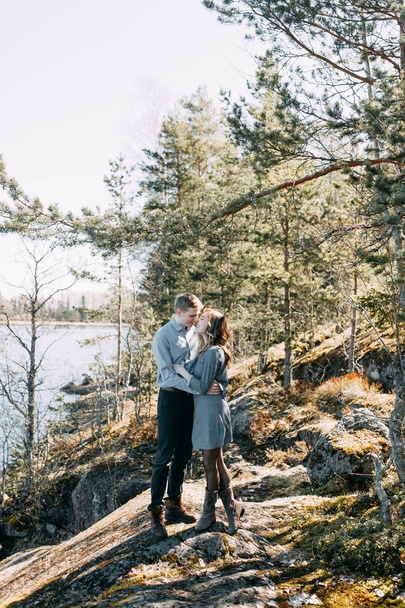 Pre-wedding photo shoot in the forest in nature, in the form of walking and traveling. Beauty of the North and Russia. Loving people and beautiful scenery. They laugh, sit and smile. Beautiful couple - Foto, Imagen