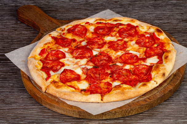 Maukas pizza salami ja juusto puulaudalla
 - Valokuva, kuva
