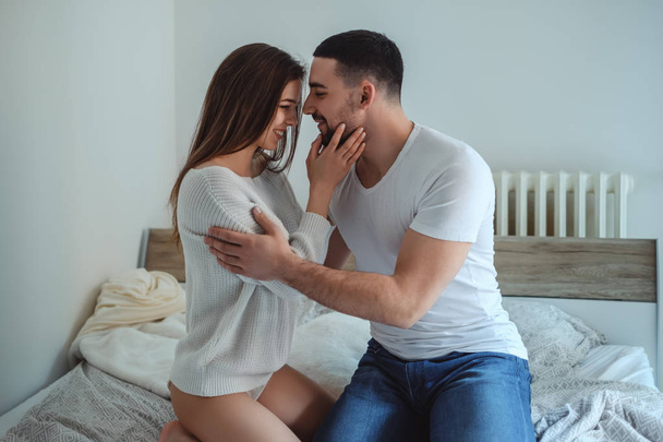 Couple holding each other and smiling on the bed - Photo, Image
