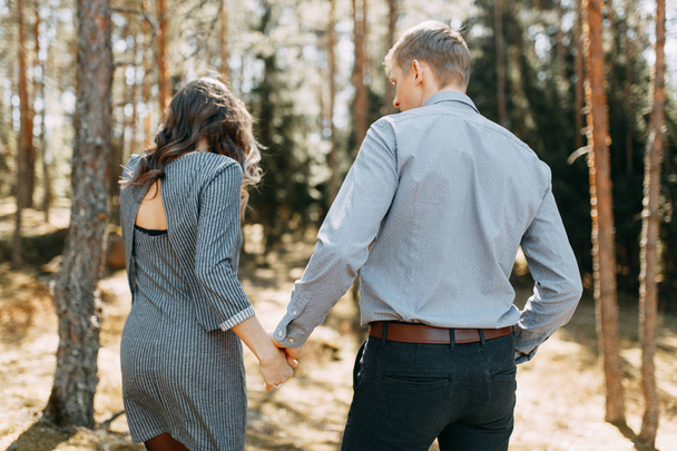 Pre-wedding photo shoot in the forest in nature, in the form of walking and traveling. Beauty of the North and Russia. Loving people and beautiful scenery. They laugh, sit and smile. Beautiful couple - Foto, imagen