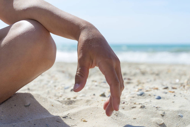 Junge entspannt am Strand mit Sand, Körperteilen, Lotusposition - Foto, Bild