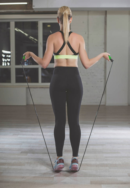 Good shaped woman is training in fitness room  - Фото, зображення