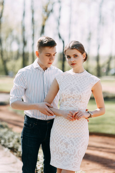 Beautiful young couple in the Park on a Sunny day, loving and happy. Walk and laugh together. Pre-wedding shooting in nature. Elegant style in clothes like celebrities - Fotoğraf, Görsel