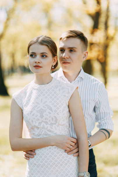 Beautiful young couple in the Park on a Sunny day, loving and happy. Walk and laugh together. Pre-wedding shooting in nature. Elegant style in clothes like celebrities - Fotografie, Obrázek