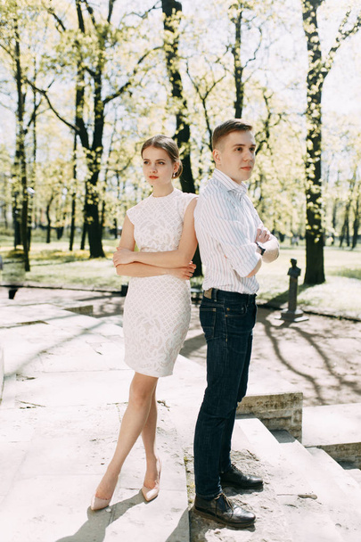 Beautiful young couple in the Park on a Sunny day, loving and happy. Walk and laugh together. Pre-wedding shooting in nature. Elegant style in clothes like celebrities - Zdjęcie, obraz
