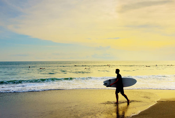 Surfer with surfboard walk on tropical beach at sunset, Bali island, Indonesia - Fotoğraf, Görsel