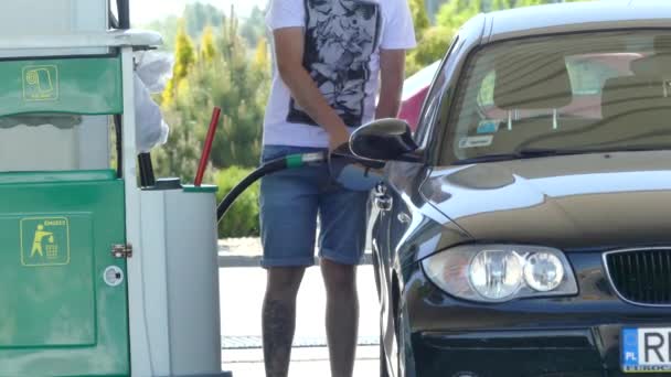 Brno, República Checa - 6 de mayo de 2018: El hombre está repostando el coche en la gasolinera cerca de la ciudad
. - Metraje, vídeo
