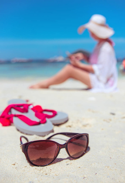 Mulher relaxada usando um smartphone em uma praia tropical
 - Foto, Imagem