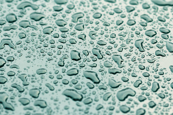 Kék csepp eső, vagy a víz csepp a motorháztető az autó. Az eső esik a felszínen az autóból vagy a vas felszíni áramlás. Absztrakt háttér és a Design a víz felületi. - Fotó, kép