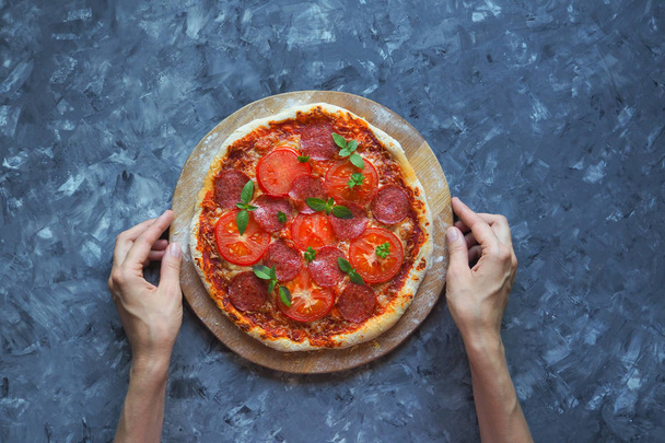 Homemade pepperoni pizza on a blue-grey kitchen table. Top view - Photo, Image