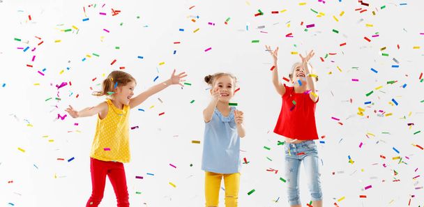 boldog gyermekek, ünnepnapokon van móka, és ugrás a színes konfetti fehér háttere - Fotó, kép