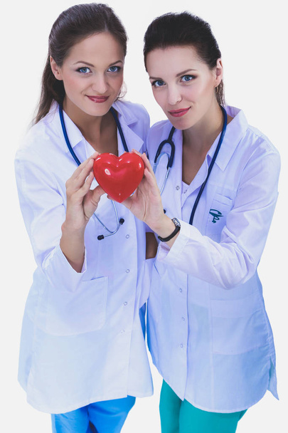 Dvě ženy doktor držící červené srdce, izolované na bílém pozadí. Dvě ženy doktor - Fotografie, Obrázek