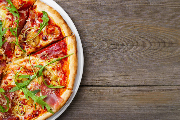 Pizza with prosciutto and arugula, copy space. - Zdjęcie, obraz